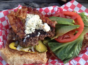 One all beef patty, mustard sauce, lettuce, tomato, avocado, bacon, blue cheese, pickles, and onions on a whole wheat bun!